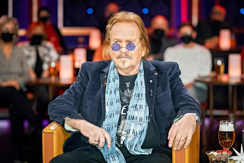 Frank Zander sitzt auf einem Sessel und schaut in die Ferne 