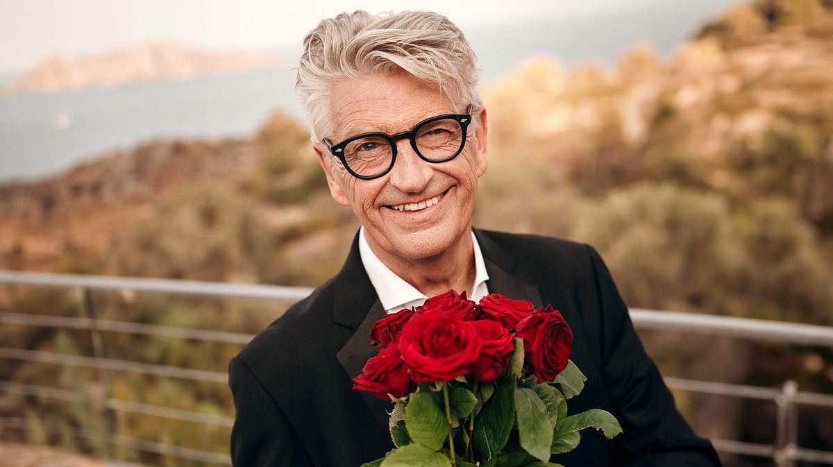 Franz Stärk hält einen Strauß Rosen in der Hand