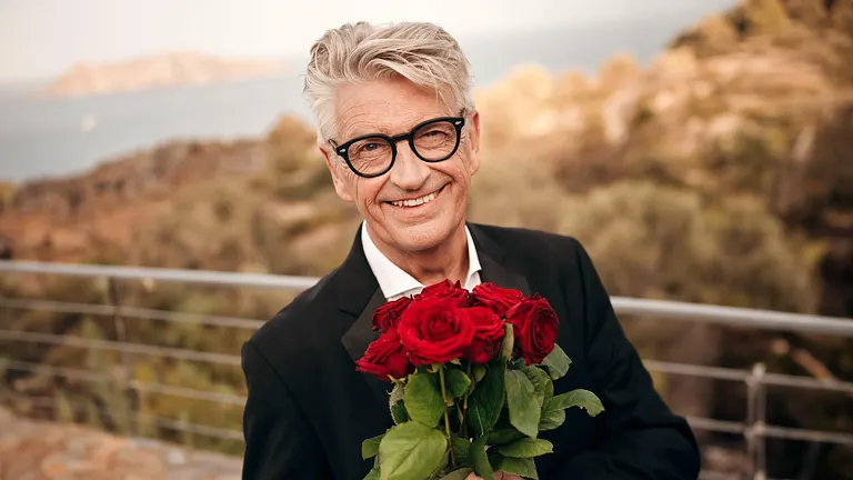 Franz Stärk hält einen Strauß Rosen in der Hand