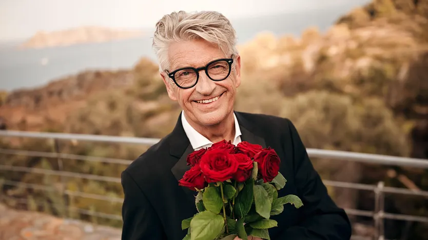 Franz Stärk hält einen Strauß Rosen in der Hand