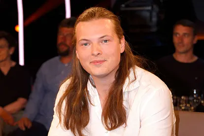 Gabriel Kelly blickt in die Kamera und lächelt verlegen.