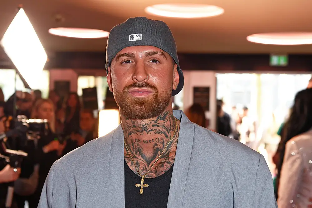 Gigi Birofio, hier mit grauem Blazer und grauer Cap, blickt ernst in die Kamera. Gigi Birofio, hier mit grauem Blazer und grauer Cap, blickt ernst in die Kamera.