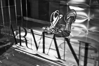 Giorgio Armani Damenschuhe in einer Auslage, davor der berühmte Armani-Schriftzug auf dem Glas.