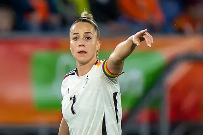 Giulia Gwinn steht im Deutschlandtrikot auf dem Platz zeigt mit dem Finger in die Ferne. 