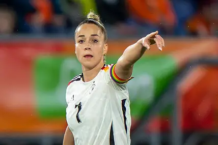 Giulia Gwinn steht im Deutschlandtrikot auf dem Platz zeigt mit dem Finger in die Ferne. 