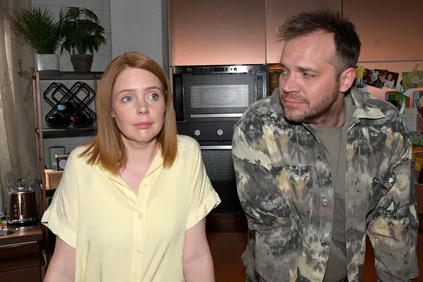 Erik und Toni stehen nebeneinander in der Küche. Er schaut sie an, sie blick resigniert nach vorne.
