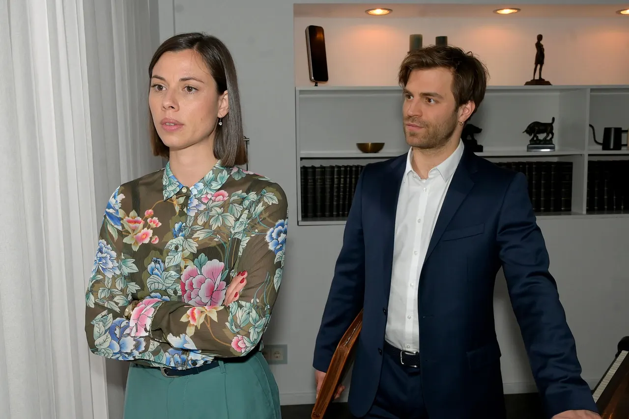 Szene aus GZSZ: Matilda mit verschränkten Armen, Julian steht hinter ihr. Das gute Verhältnis der Zwillinge droht zu zerbrechen. - Foto: RTL / Rolf Baumgartner