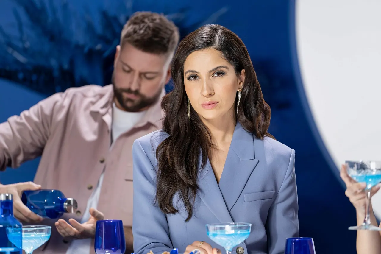 gzsz-laura-erfährt-wahrheit GZSZ-Szene: Laura-Darstellerin Chryssanthi Kavazi sitzt vor einem Drink und guckt ernst, im Hintergrund mixt John-Mime Felix von Jascheroff einen Cocktail. - Foto: RTL / Pascal Bünning
