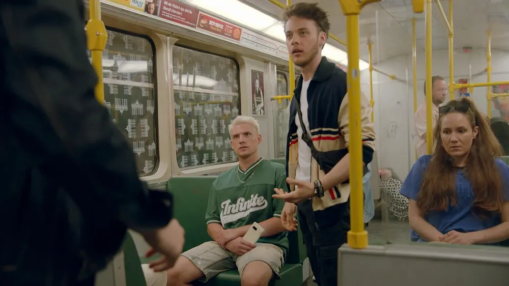 GZSZ-Szene: Robin steht in der U-Bahn, Moritz sitzt auf einem Sitz neben ihm GZSZ-Szene: Robin steht in der U-Bahn, Moritz sitzt auf einem Sitz neben ihm