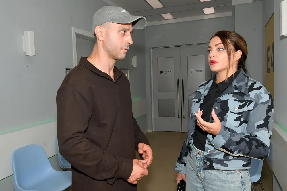 Tobias mit Cap schaut Emily im Krankenhaus kritisch an.