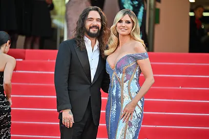 Heidi Klum und Tom Kaulitz stehen auf dem roten Teppich, er trägt einen schwarzen Anzug und sie ein schulterfreies Paillettenkleid.
