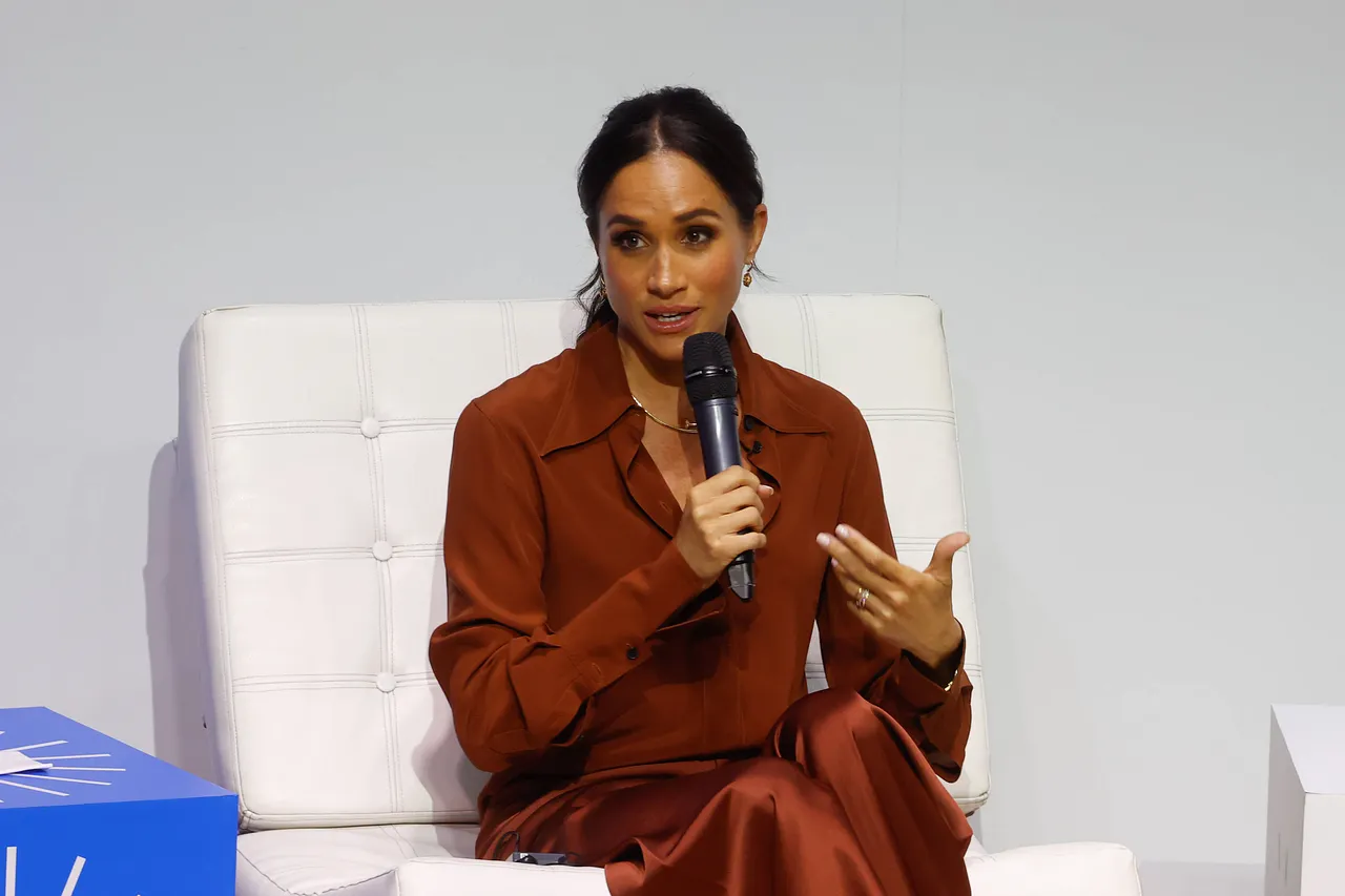 herzogin-meghan-betrugsvorwuerfe-imago830030343 Herzogin Meghan hält ein Mikrofon in der Hand und sieht sehr ernst aus. - Foto: IMAGO / Anadolu Agency