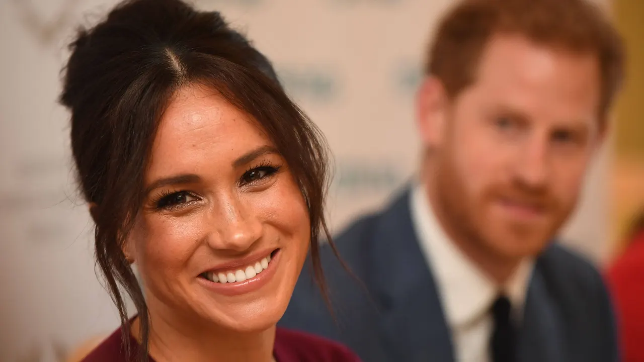 Herzogin Meghan teilt familiäre Einblicke Meghan mit Hochsteckfrisur lächelt. Prinz Harry ist im Hintergrund - Foto: IMAGO / i Images