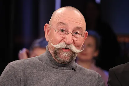 Horst Lichter trägt einen grauen Rollkragenpullover. Für den Sommer hat er sich aber ein freizügigeres Outfit ausgesucht.