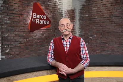 Horst Lichter lehnt sich an den Händlertisch im "Bares für Rares"-Studio.