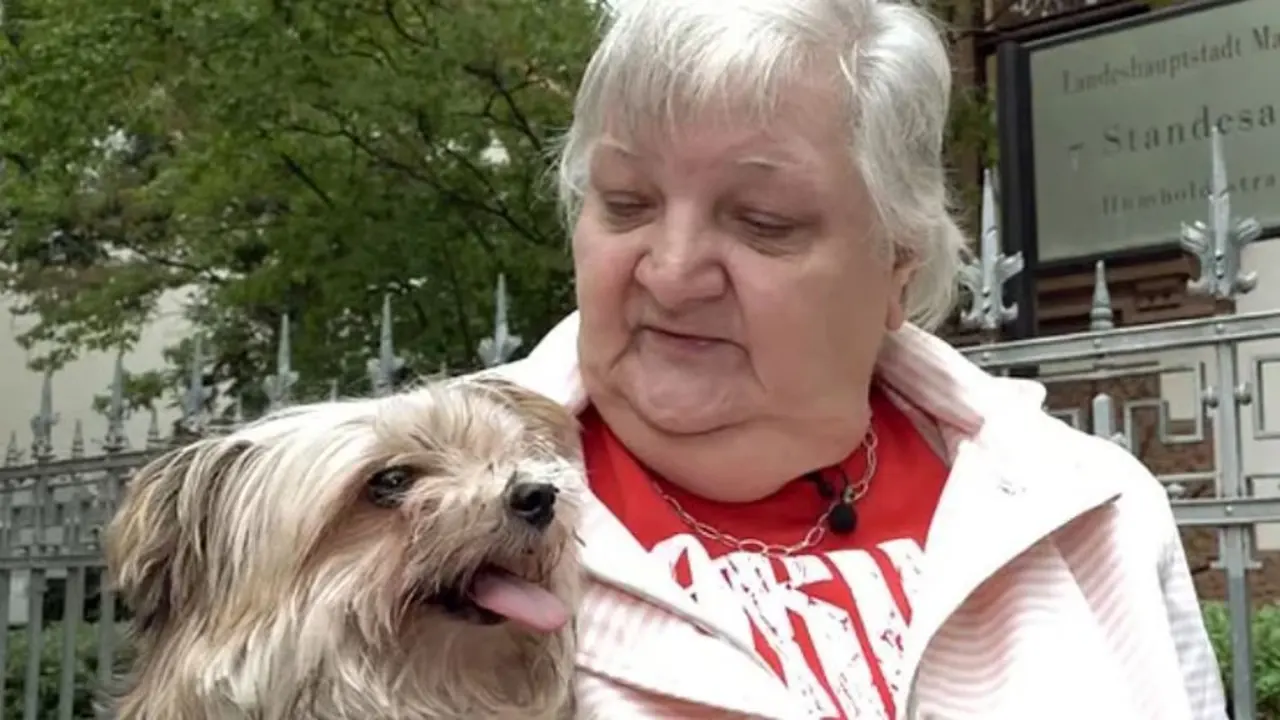 Sigg schaut ihren Hund an, der sehr glücklich aussieht und seine Zunge ausstreckt.