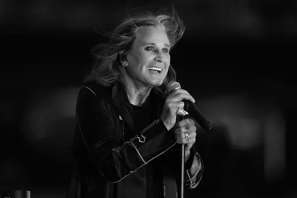 Ozzy Osbourne schaut lächelnd in die Ferne.