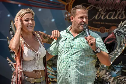 Willi Herren und Ehefrau Jasmin Herren zeigten sich gemeinsam bei einer Open-Air-Veranstaltung im Sommer 2019. Jasmin trug ein weißes Top mit Weste, während Willi ein kariertes grünes Hemd anhatte.