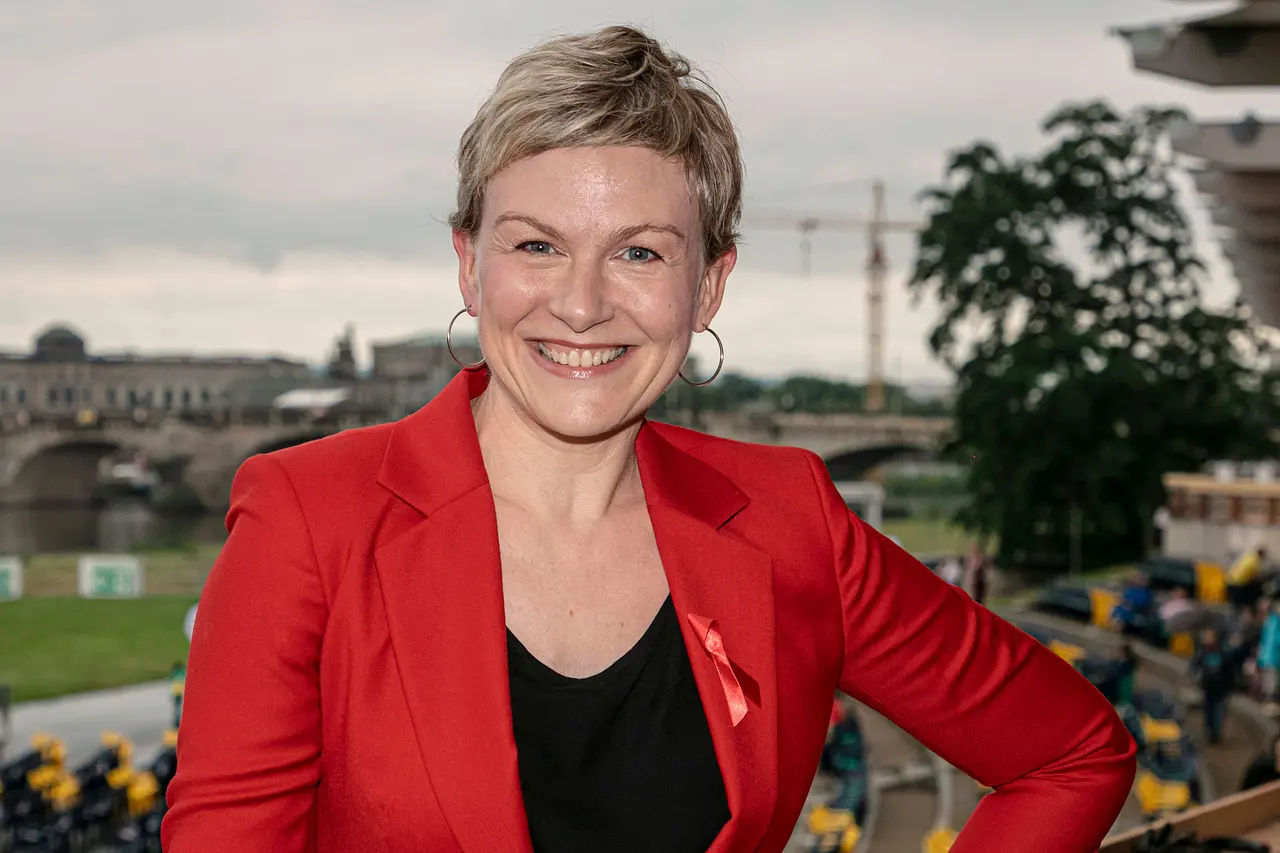 imago125094991 Karen Heinrichs im roten Blazer mit schwarzem Shirt lächelt in die Kamera. - Foto: IMAGO / Andreas Weihs
