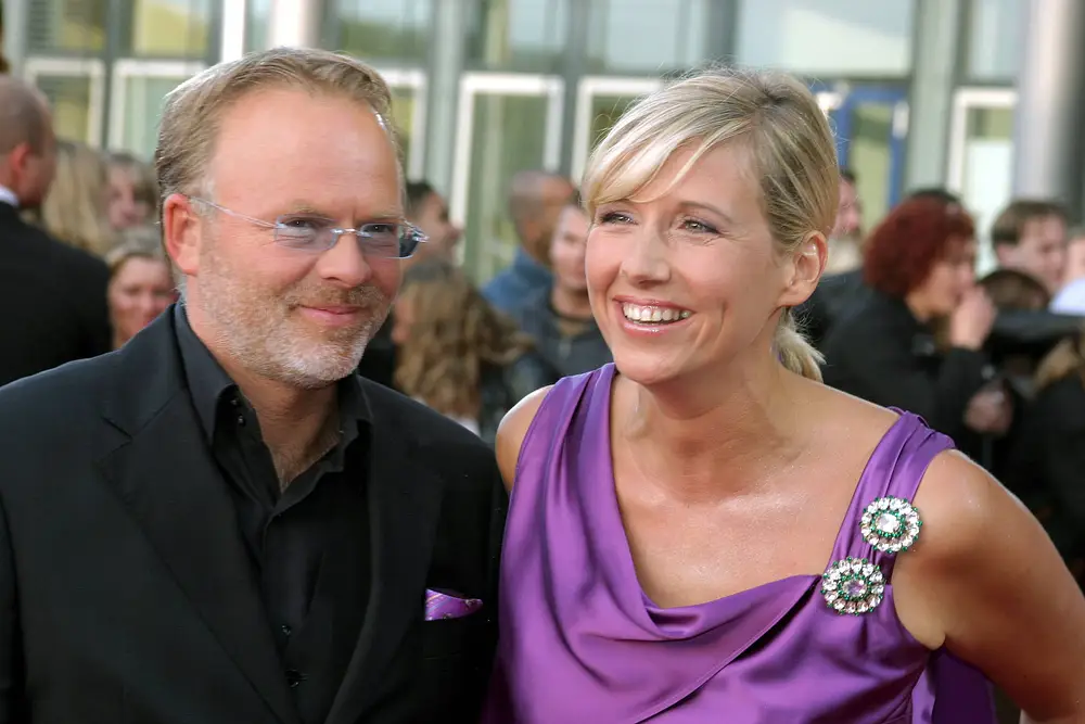 Fernsehmoderatorin Andrea Kiewel und ihr damaliger Lebensgefährte Theo Naumann im Jahr 2004 bei der Verleihung des Deutschen Fernsehpreises. Sie stehen nebeneinander und lächeln. Fernsehmoderatorin Andrea Kiewel und ihr damaliger Lebensgefährte Theo Naumann im Jahr 2004 bei der Verleihung des Deutschen Fernsehpreises. Sie stehen nebeneinander und lächeln.