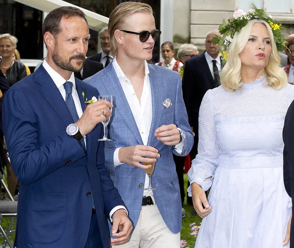 Marius Borg Høiby trägt eine Sonnenbrille und steht zwischen Kronprinz Haakon und Mette-Marit. Marius Borg Høiby trägt eine Sonnenbrille und steht zwischen Kronprinz Haakon und Mette-Marit.