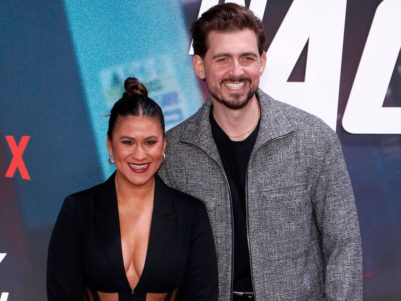 Steffi Brungs und ihr Ehemann Chris Wackert-Brungs lächeln auf dem roten Teppich eines Netflix-Events für die Kameras.