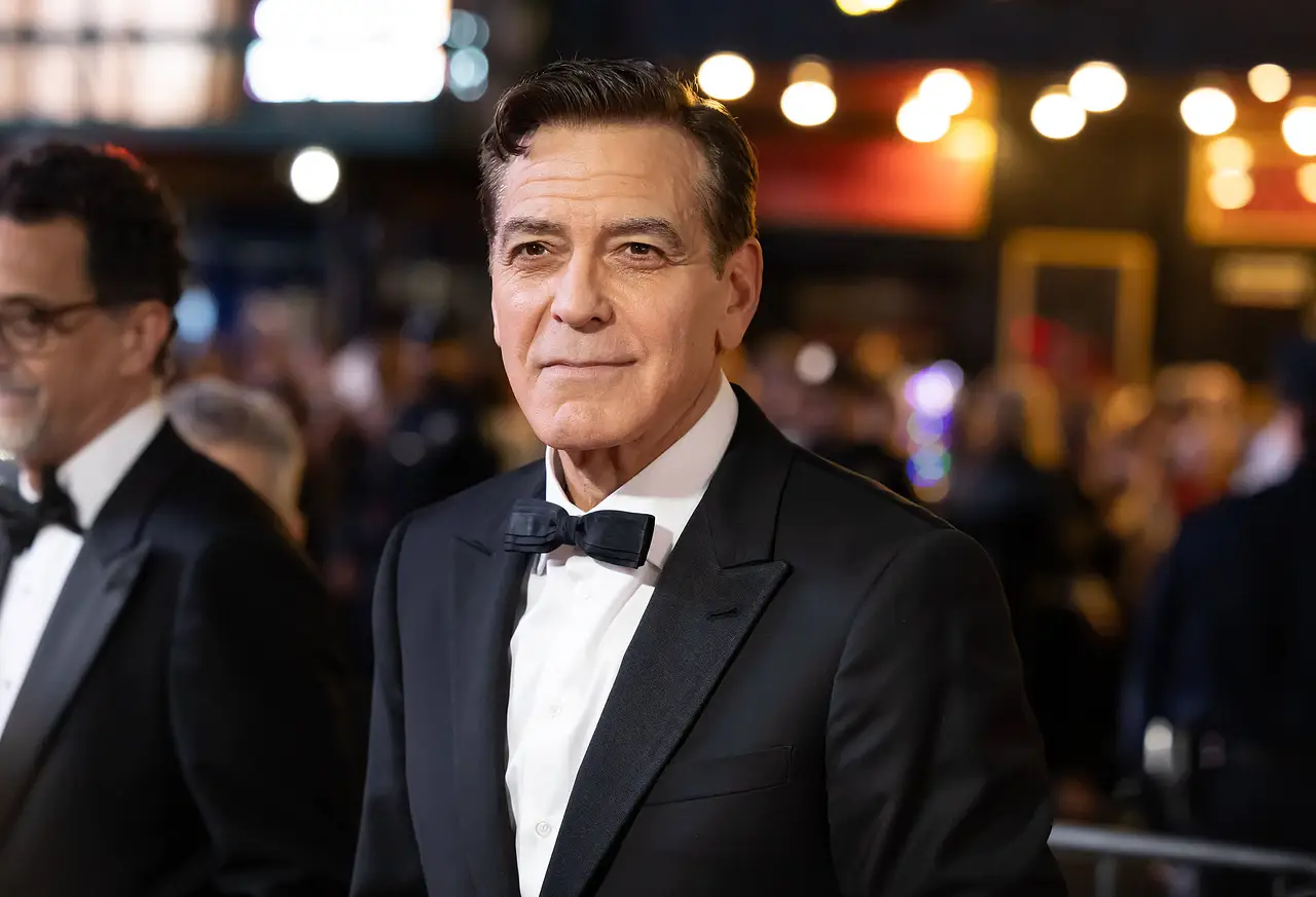 George Clooney mit Glatze Man sieht George Clooney bei einer Veranstaltung. Er trägt schwarzes Haar mit einem grauen Verlauf, ein schwarzes Jackett und eine schwarze Fliege. - Foto: IMAGO / Cover-Images