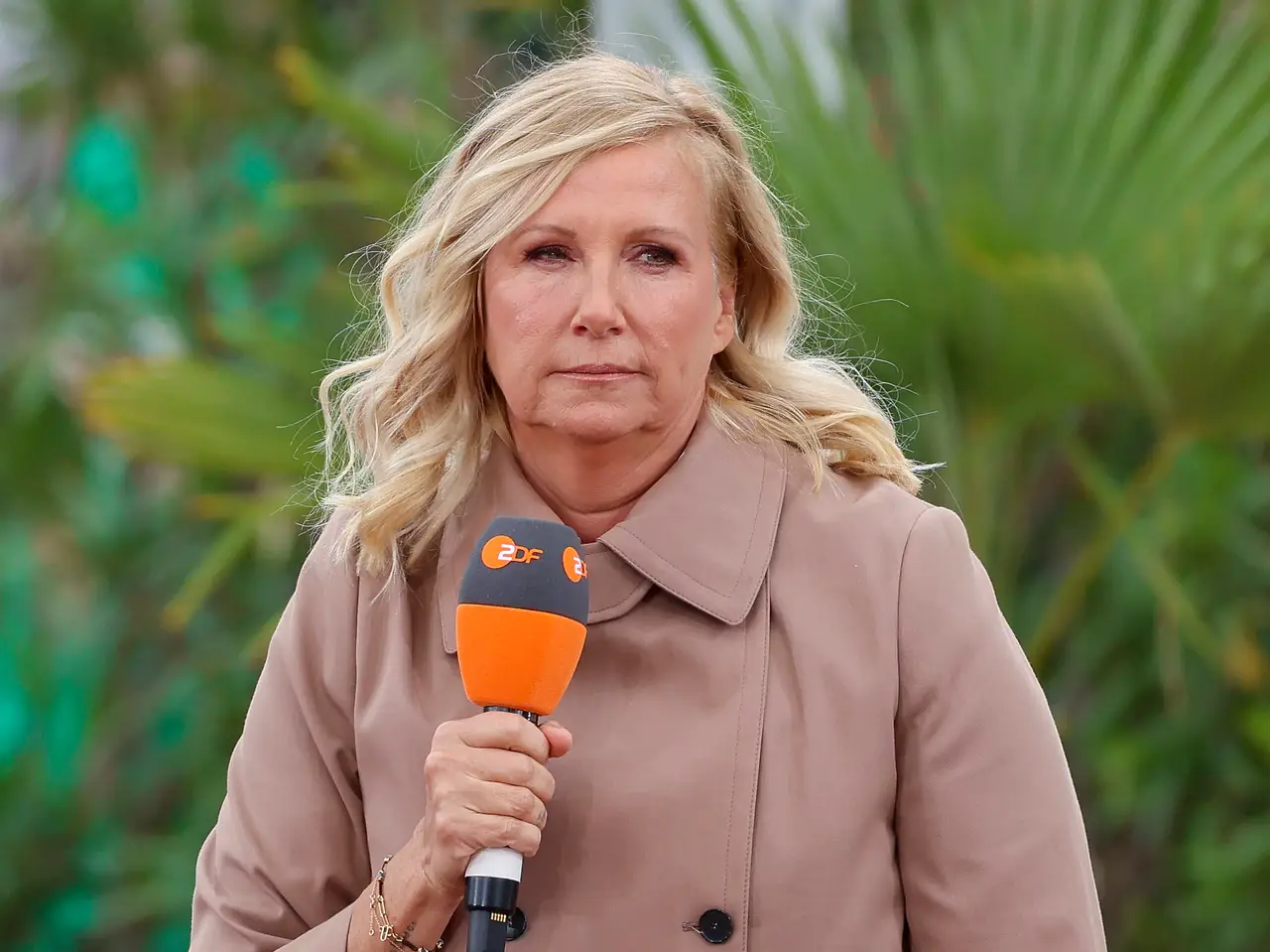 Andrea Kiewel Andrea Kiewel moderiert den ZDF-Fernsehgarten mit einem Mikrofon in der Hand und sie schaut unzufrieden. - Foto: IMAGO / DeFodi Images