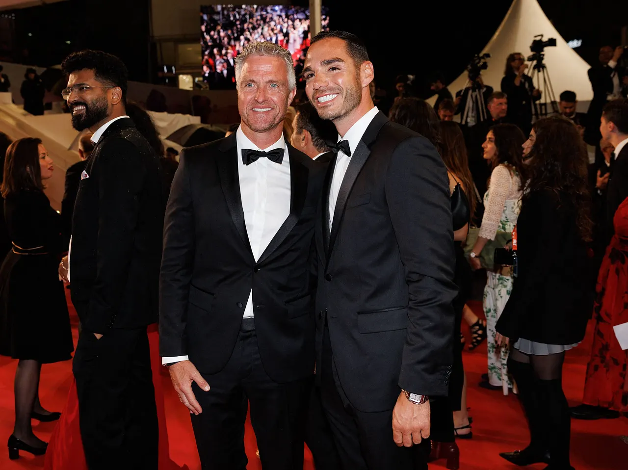 Ralf Schumacher und Lebensgefährte Étienne auf den Cannes Filmfestspielen. Ralf Schumacher und Lebensgefährte Étienne auf den Cannes Filmfestspielen. Beide lächeln in die Kamera und tragen einen schwarzen Anzug. - Foto: IMAGO / Bestimage