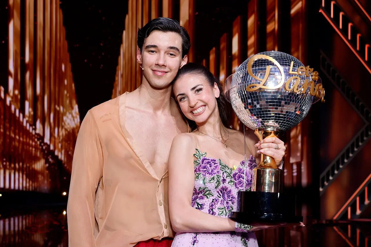 Diego Pooth und Ekaterina Leonova lächeln in die Kamera. Ekaterina hält den Lets Dance-Pokal. - Foto: IMAGO / Panama Pictures