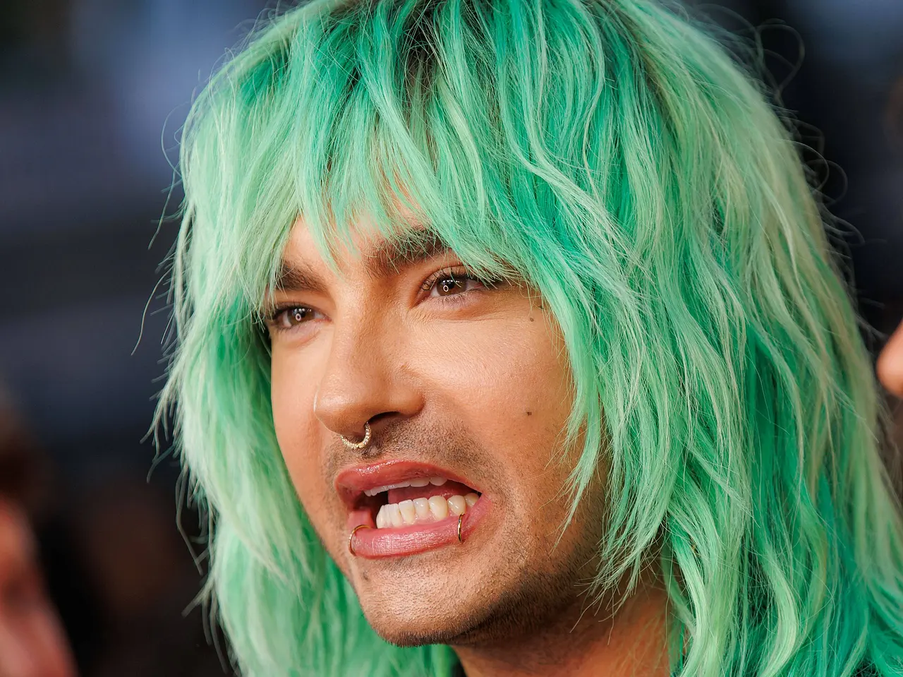 Bill Kaulitz mit grünen Haaren und nach unten verzogenem Mund. - Foto:  IMAGO / Eventpress