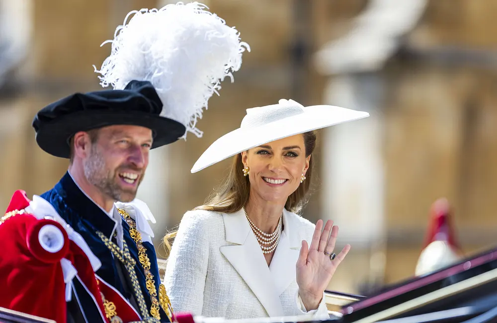 Prinz William und Prinzessin Kate sitzen in einer Kutsche. Beide lächeln, Kate winkt in Richtung der Kamera. Prinz William und Prinzessin Kate sitzen in einer Kutsche. Beide lächeln, Kate winkt in Richtung der Kamera.