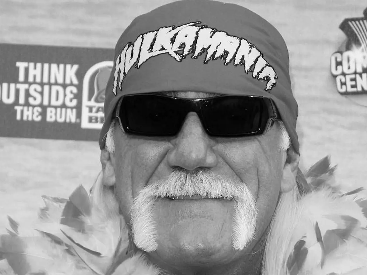 Hulk Hogan mit Bandana, Sonnenbrille und Federkette. - Foto: IMAGO / ZUMA Press Wire