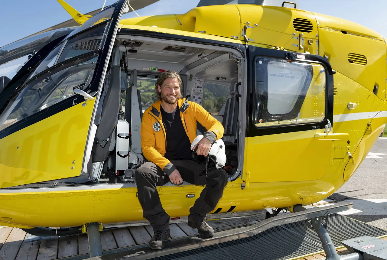 Sebastian Ströbel sitzt in einer gelben Jacke und einer schwarzen Hose in einem gelben Helikopter. - Foto:  IMAGO / Stephan Görlich