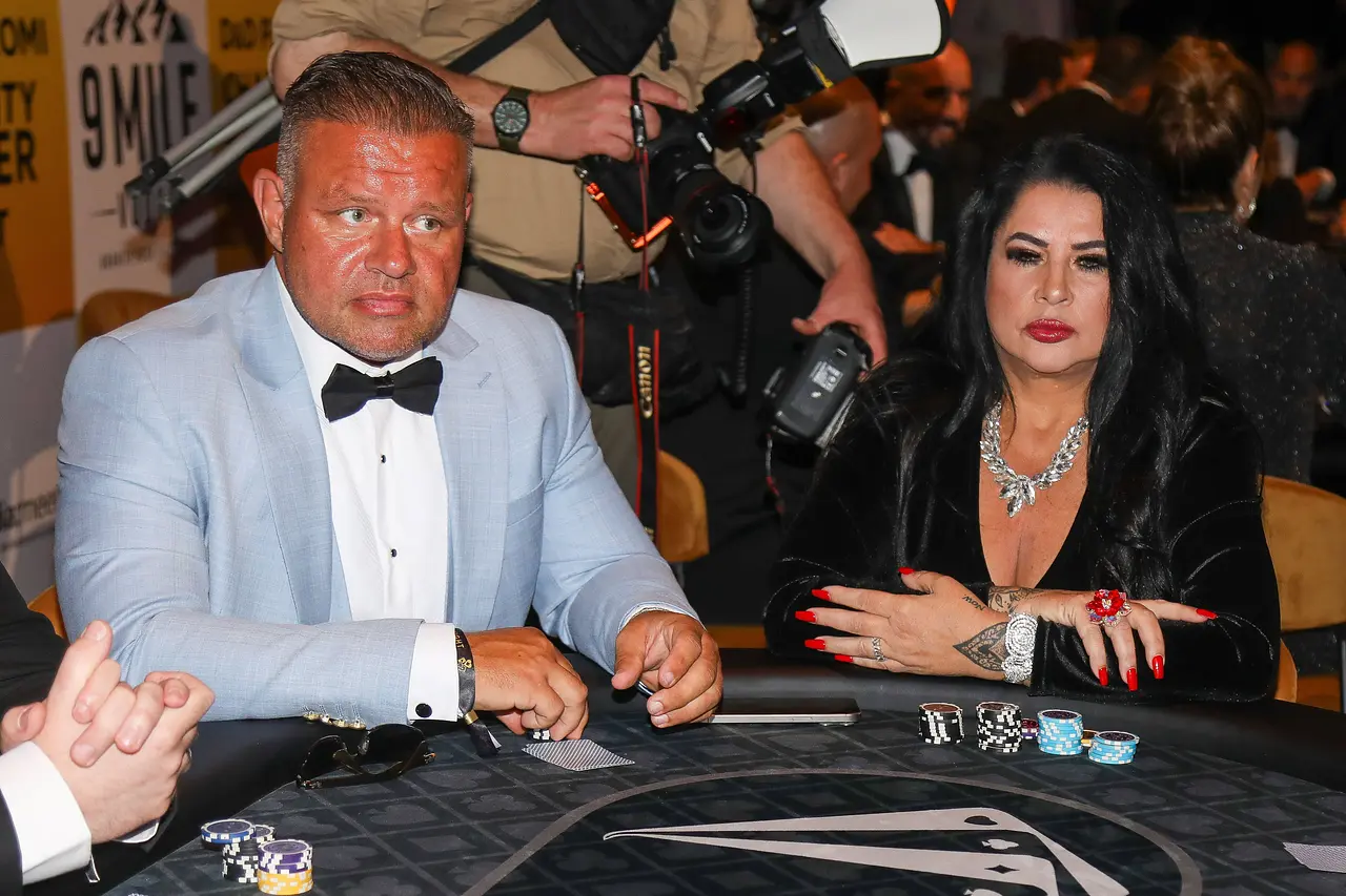 Stefan Braun und Iris Klein sitzen glamourös gekleidet und mit ernster Miene an einem Pokertisch.