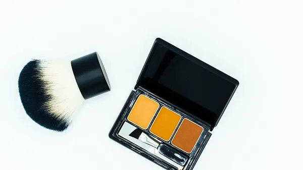 Mit einem Kabuki-Pinsel Make-up auftragen.