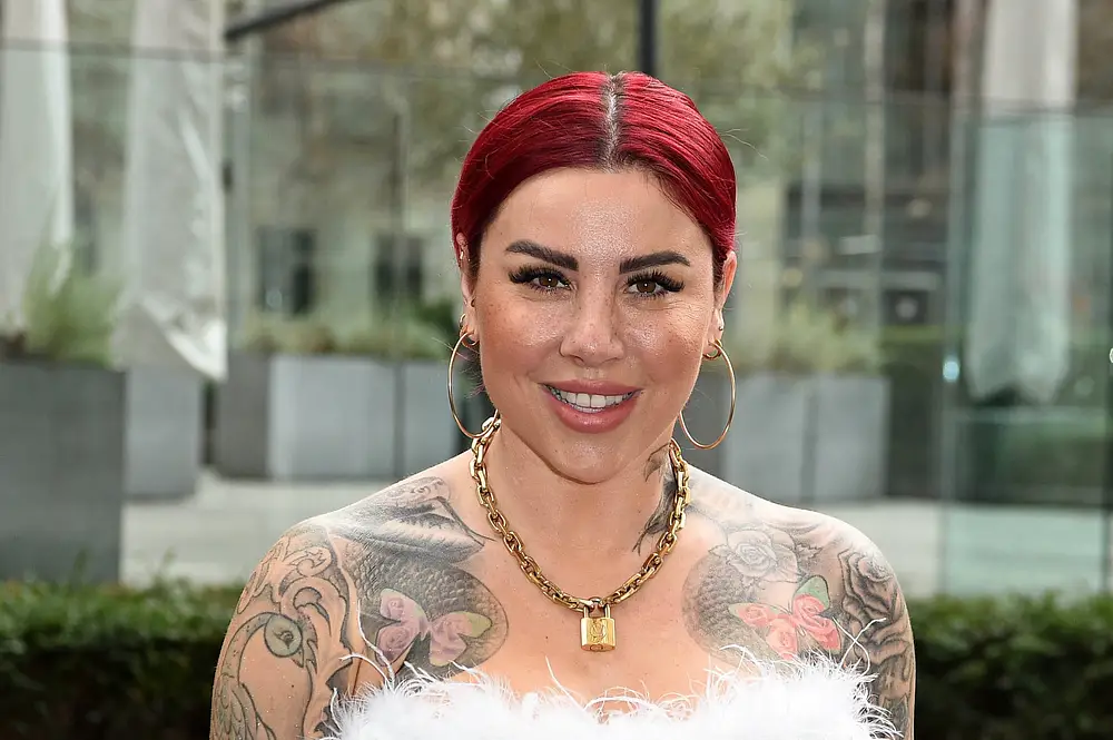 Kate Merlan, hier mit roten Haaren und großen Creolen, lächelt in die Kamera. Kate Merlan, hier mit roten Haaren und großen Creolen, lächelt in die Kamera.