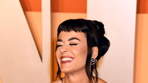 Katy Perry lächelt schräg an der Kamera vorbei und hat die Hände in die Hüfte gestemmt. Sie trägt ein goldenes Abendkleid und hat einen kurzen Pony - Foto: IMAGO / Cover-Images