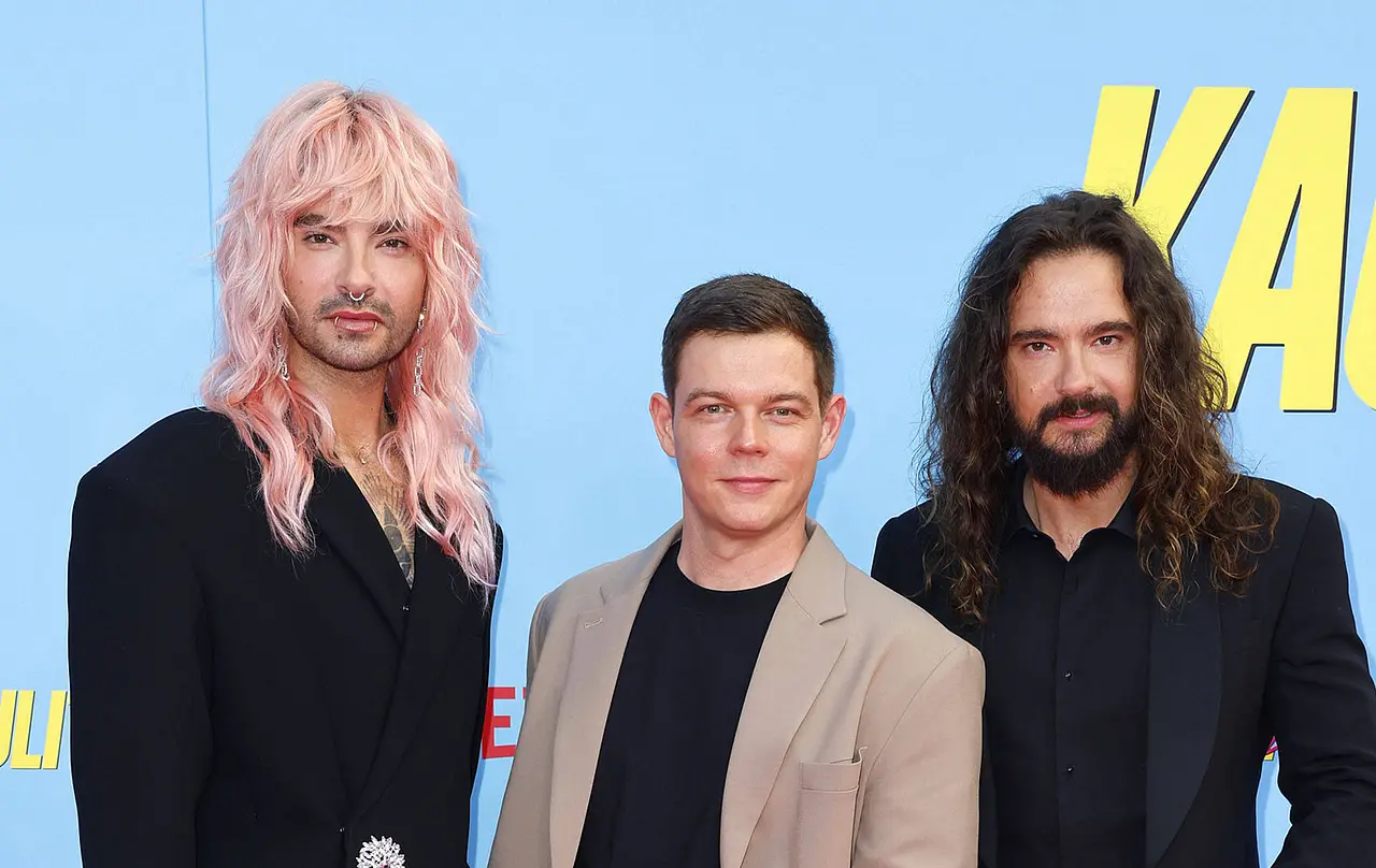 kaulitz-streit Bill Kaulitz, Georg Listing und Tom Kaulitz schauen vor blauem Hintergrund ernst in die Kamera. - Foto: Imago/APress