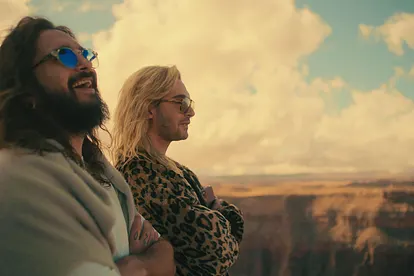 Tom und Bill stehen lachend und mit verschränkten Armen an einer Schlucht.