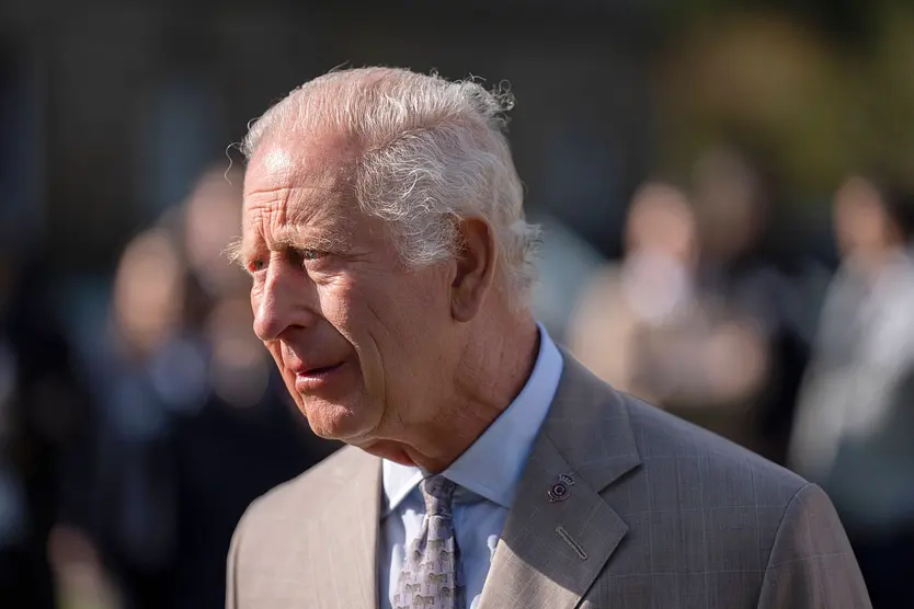 Prinz Charles guckt zur Seite und wird von der Sonne geblendet. 