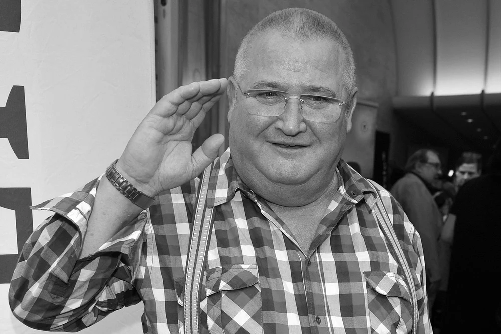 Horst Krause schaut in die Kamera, lächelt leicht und hebt die Hand zum Gruß Horst Krause schaut in die Kamera, lächelt leicht und hebt die Hand zum Gruß