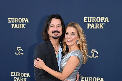 Lanny Lanner und Stefanie Hertel umarmen sich vor einer Fotowand. Beide wirken glücklich und zufrieden. 