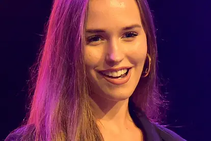 Laura Müller steht auf einer Bühne mit einem Mikrofon in der Hand