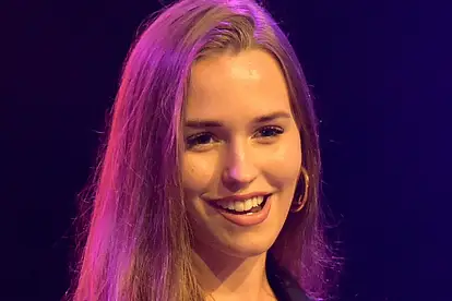 Laura Müller steht auf einer Bühne mit einem Mikrofon in der Hand