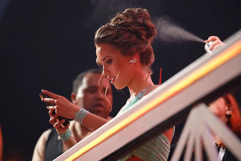 Laura Müller 2020 bei "Let's Dance": Sie steht in eine türkisfarbenen Kleid am Bühnenrand und schaut fassungslos auf ihr Handy. 