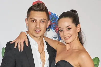 Malika Dzumaev und Zsolt Sándor Cseke in Anzug und Abendkleid bei einer Veranstaltung.