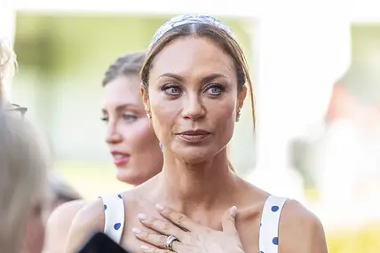 Lilly Becker hat die Hand auf ihrem Brustbein und schaut ernst.