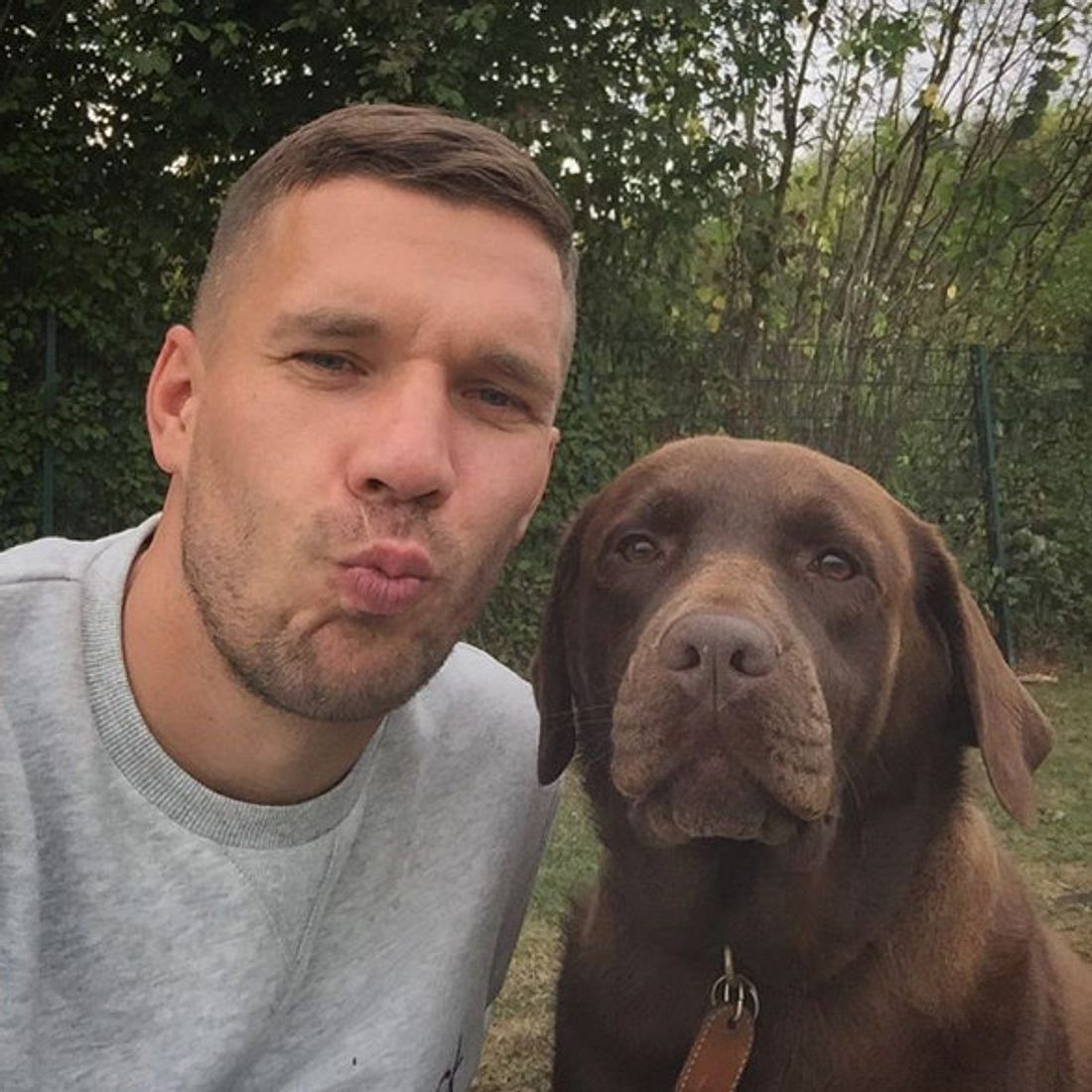 Lukas Podolski posiert mit seinem Hund