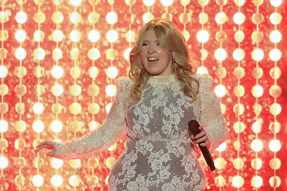 Maite Kelly steht im weißen Spitzenkleid auf der Bühne